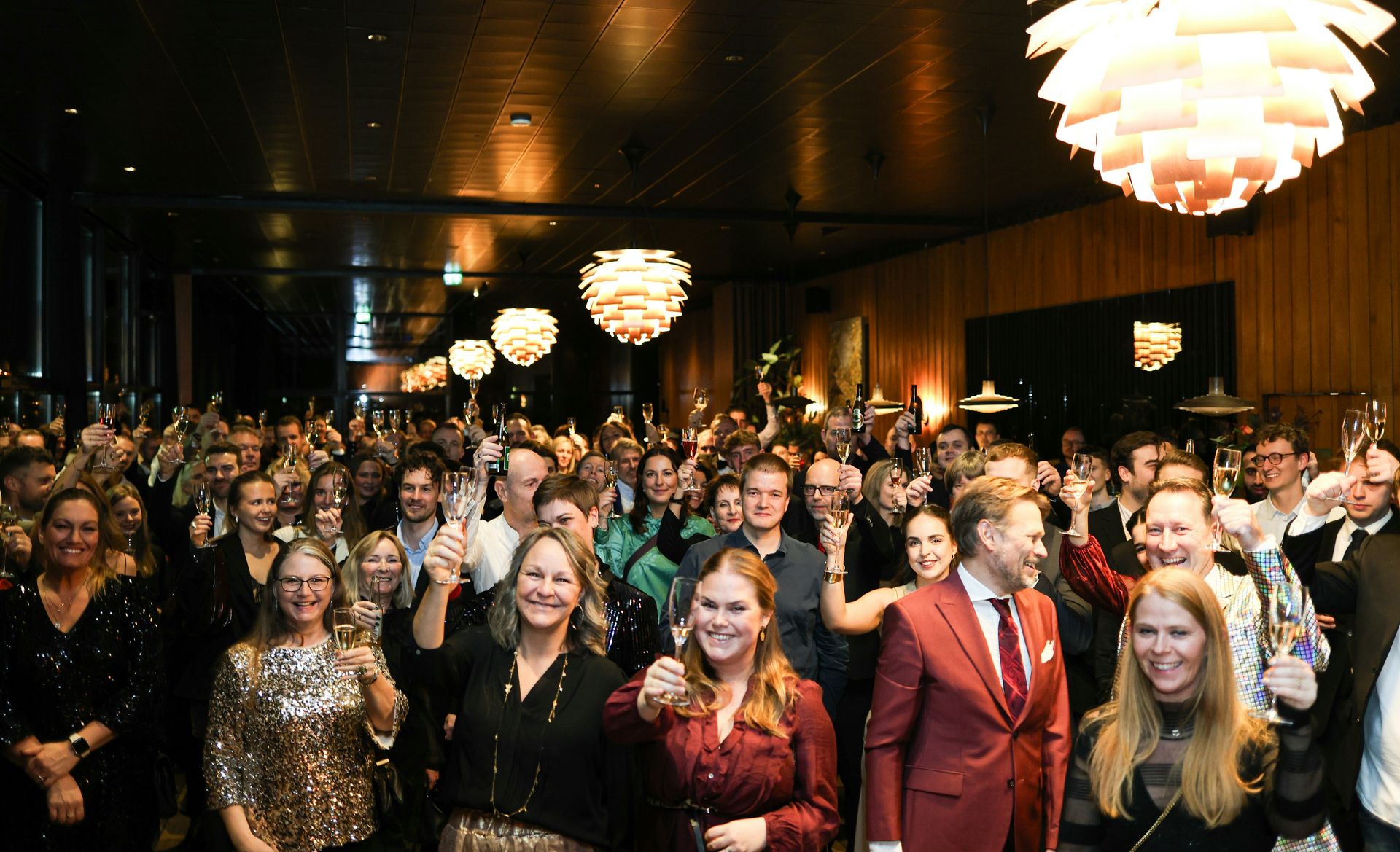 A large group of people waving at the camera